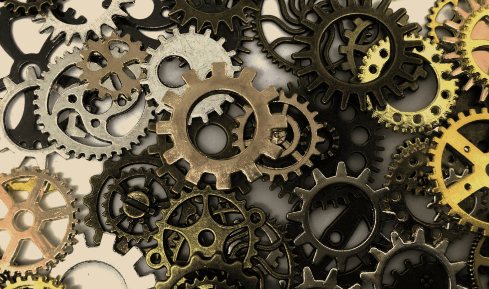Close-up of interlocking metal gears in various shapes and sizes.