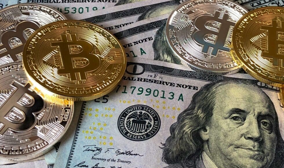 Bitcoin coins on US dollar bills with a glass globe.